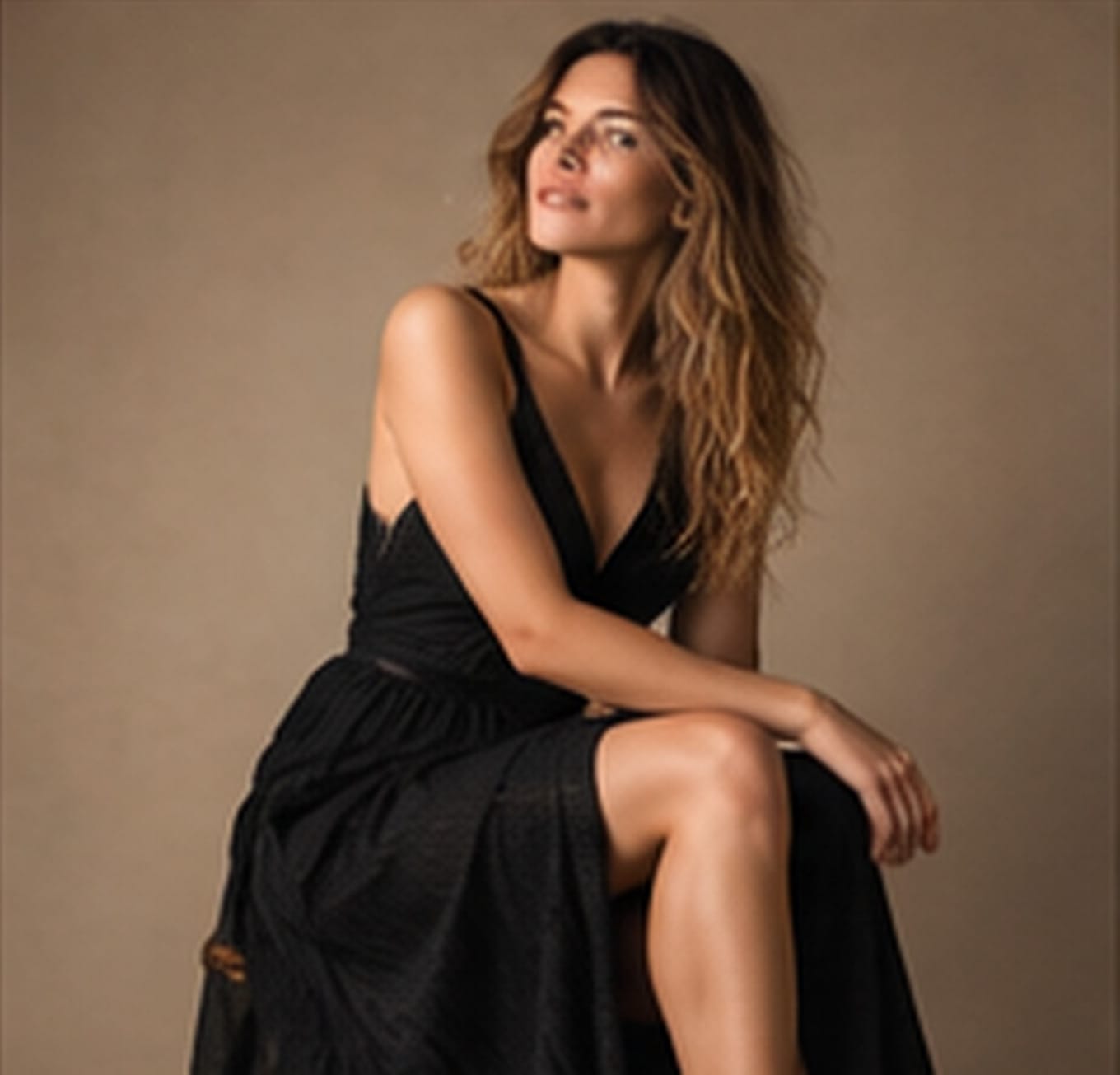Portrait féminin assis en studio, robe noire